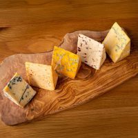5 types of cheese wedges on a board