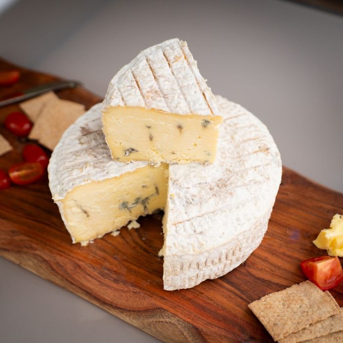 Skegness Blue Cheese 2kg with a wedge cut out.